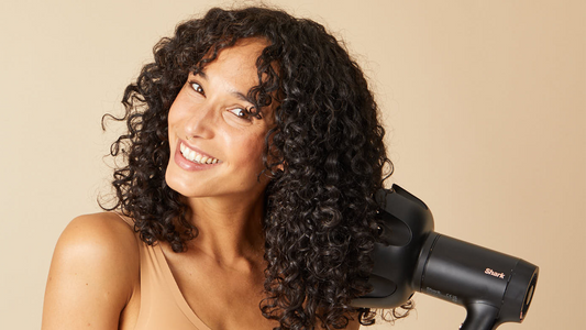 Vrouw met krullend haar gebruikt een diffuser